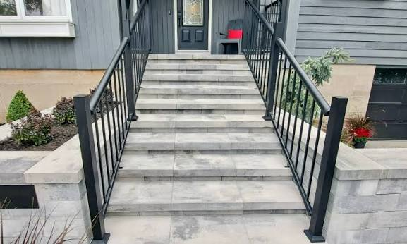 Smooth retaining wall steps with wide treads, matching landing and black railings
